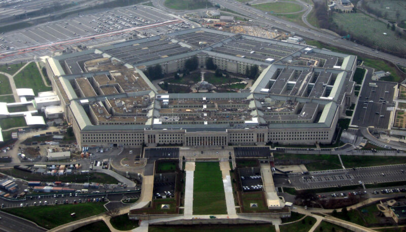 Pentagon building with US flags and media during military escalation decision